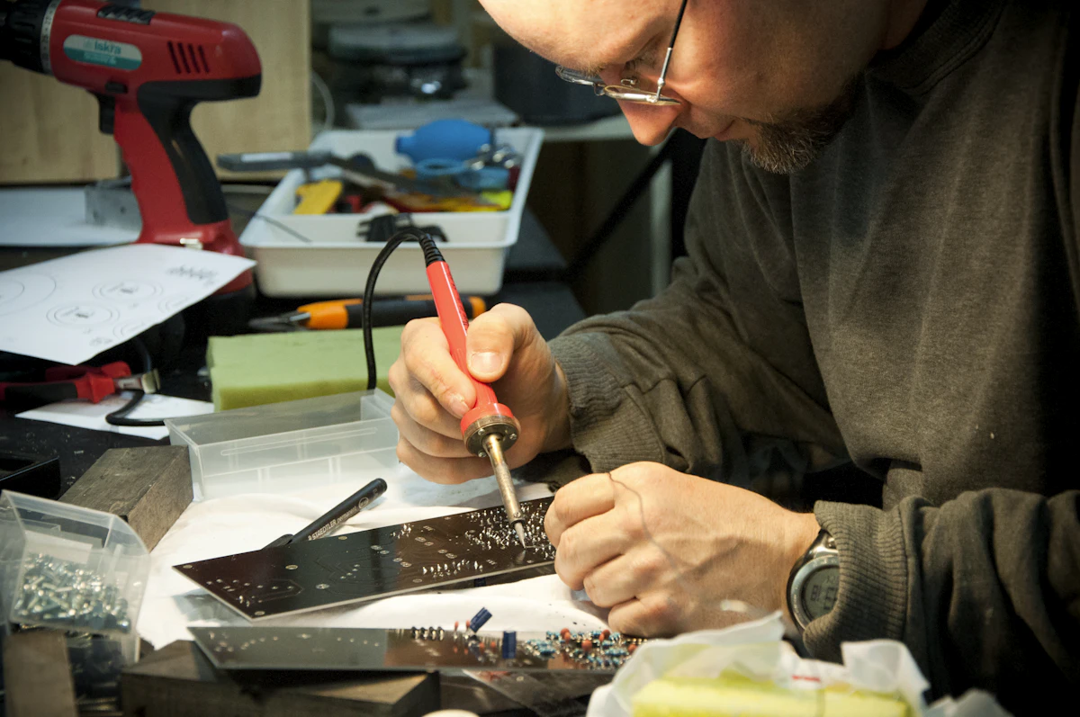 Technician soldering a TV circuit board